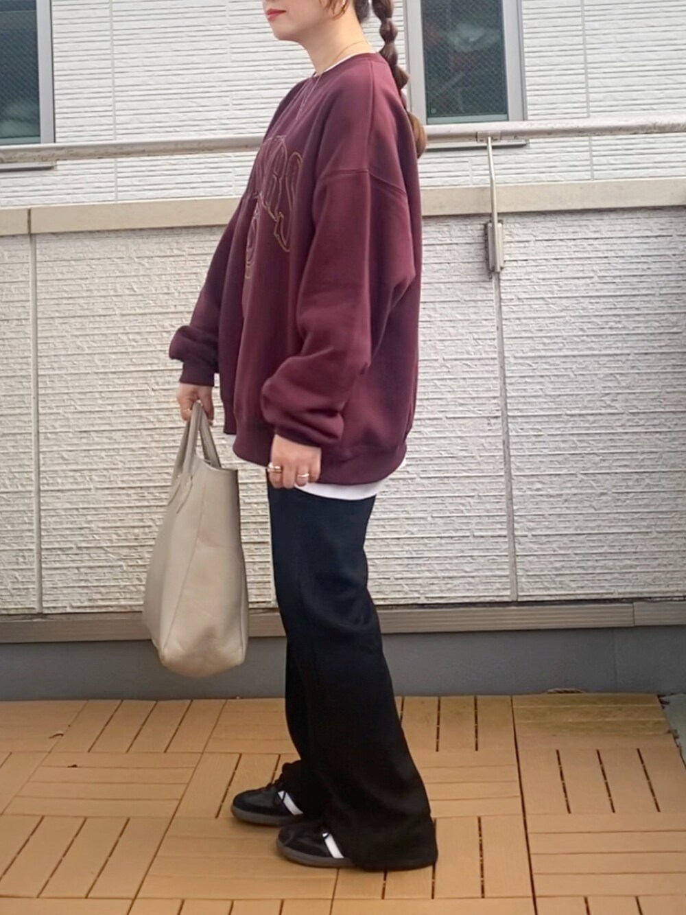 レッド系のスウェット、ブラック系のその他パンツ、ベージュ系のトートバッグを着用したレディースの秋コーディネートの3枚目の写真