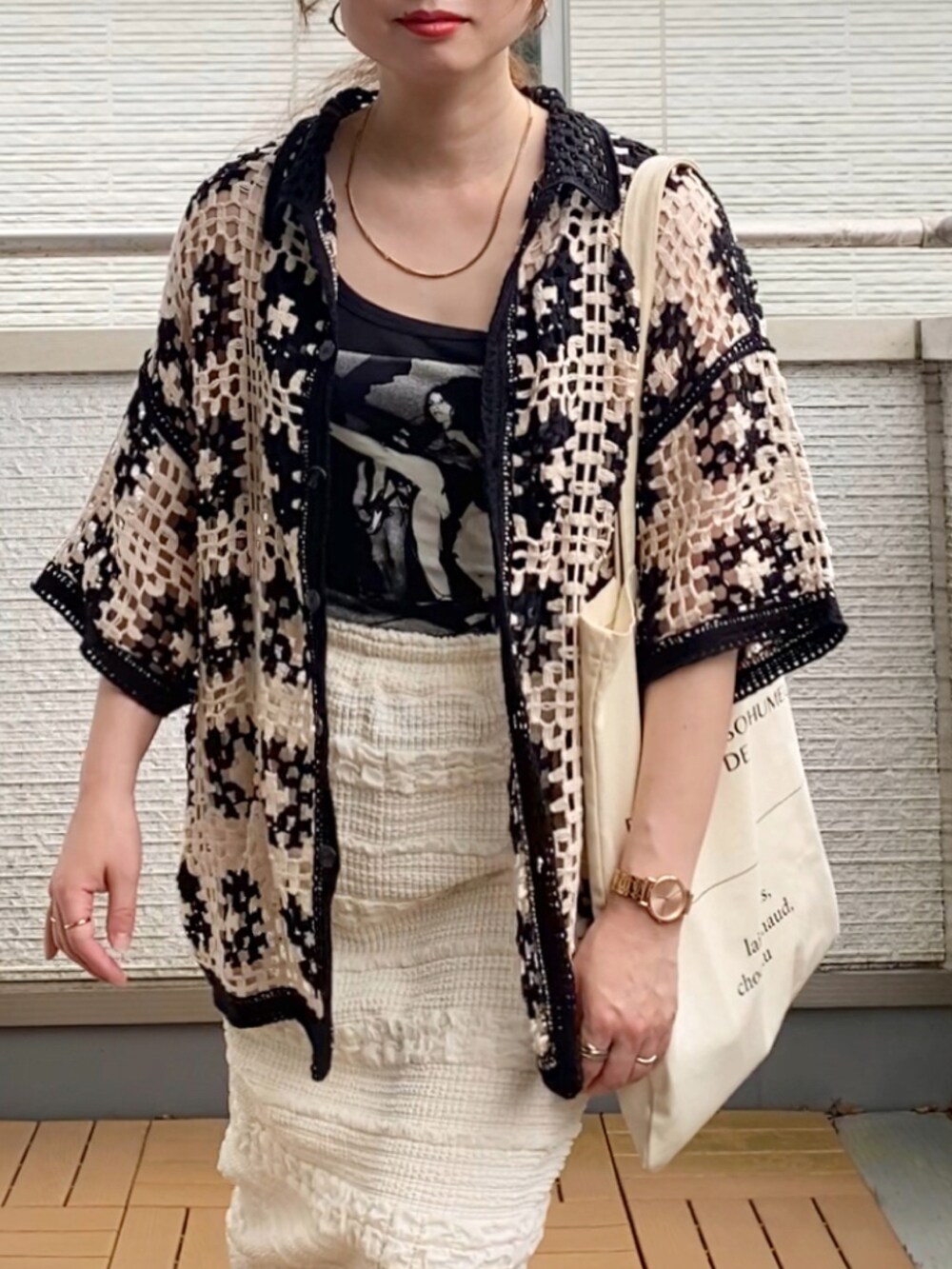 ブラック系のカーディガン/ボレロ、ホワイト系のスカート、ホワイト系のトートバッグを着用したレディースの夏コーディネートの4枚目の写真