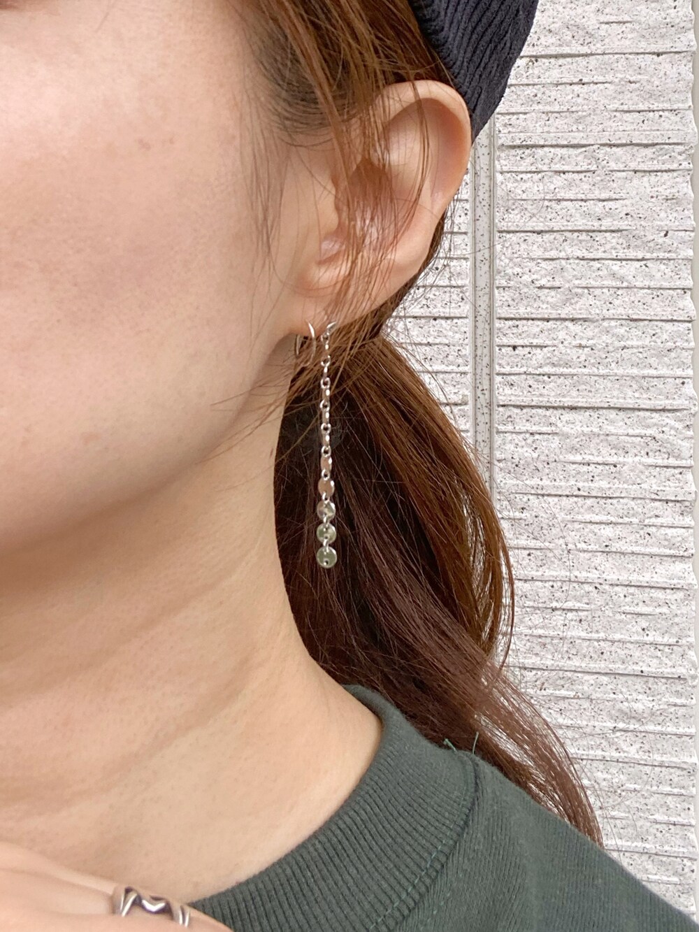 グリーン系のスウェット、ブルー系のデニムパンツ、ブラック系のショルダーバッグを着用したレディースの秋コーディネートの5枚目の写真