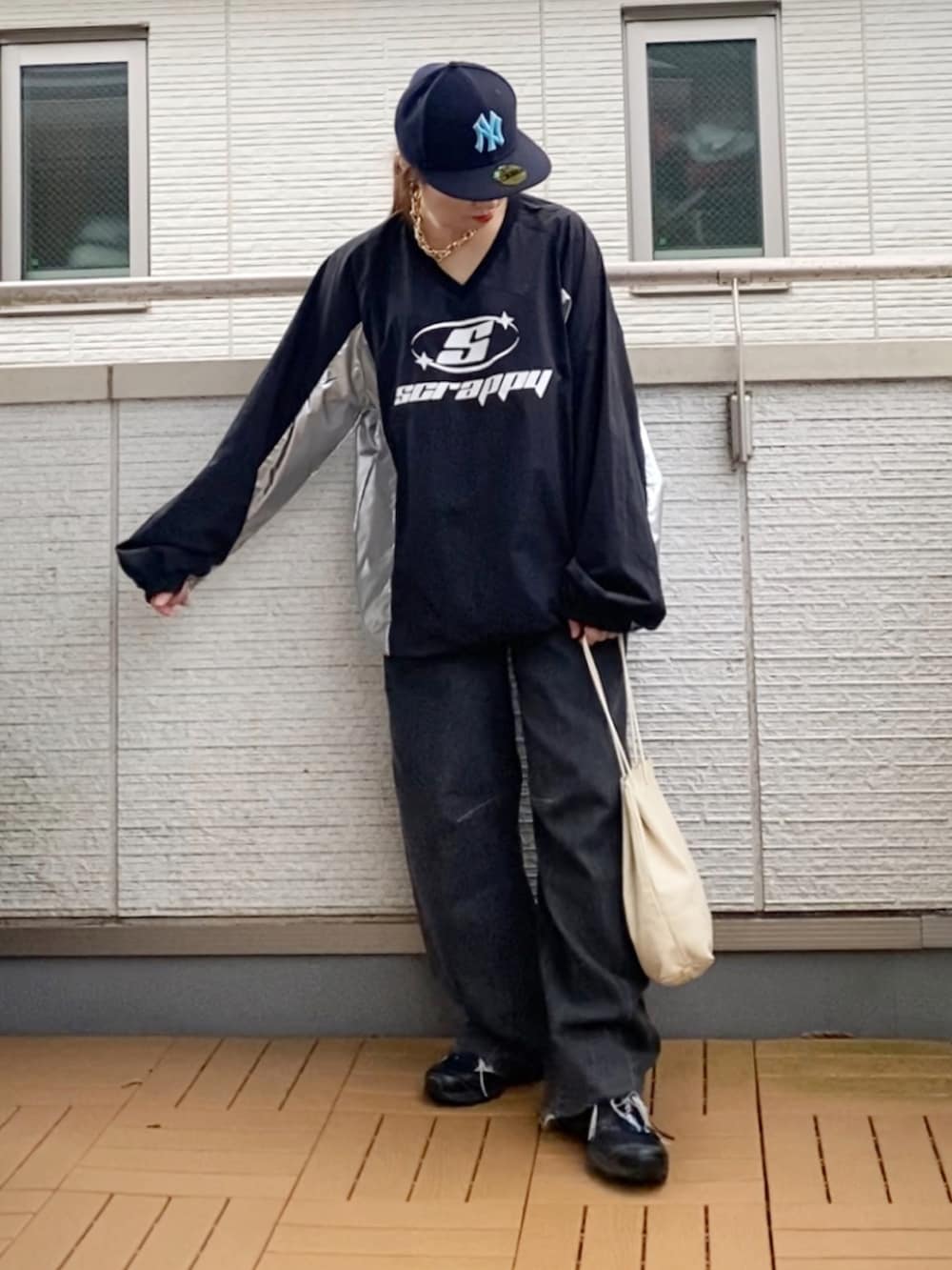 ブラック系のトップス、ブラック系のデニムパンツ、ブラック系のスニーカーを着用したレディースの秋コーディネートの2枚目の写真