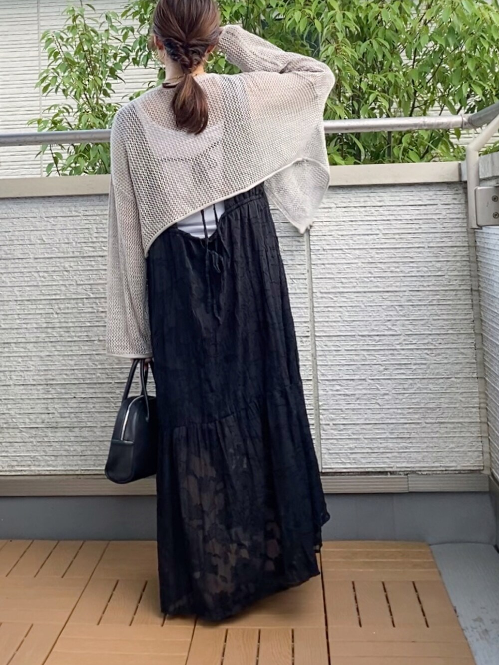 グレー系のカーディガン/ボレロ、ブラック系のワンピース、ブラック系のショルダーバッグを着用したレディースの夏コーディネートの2枚目の写真