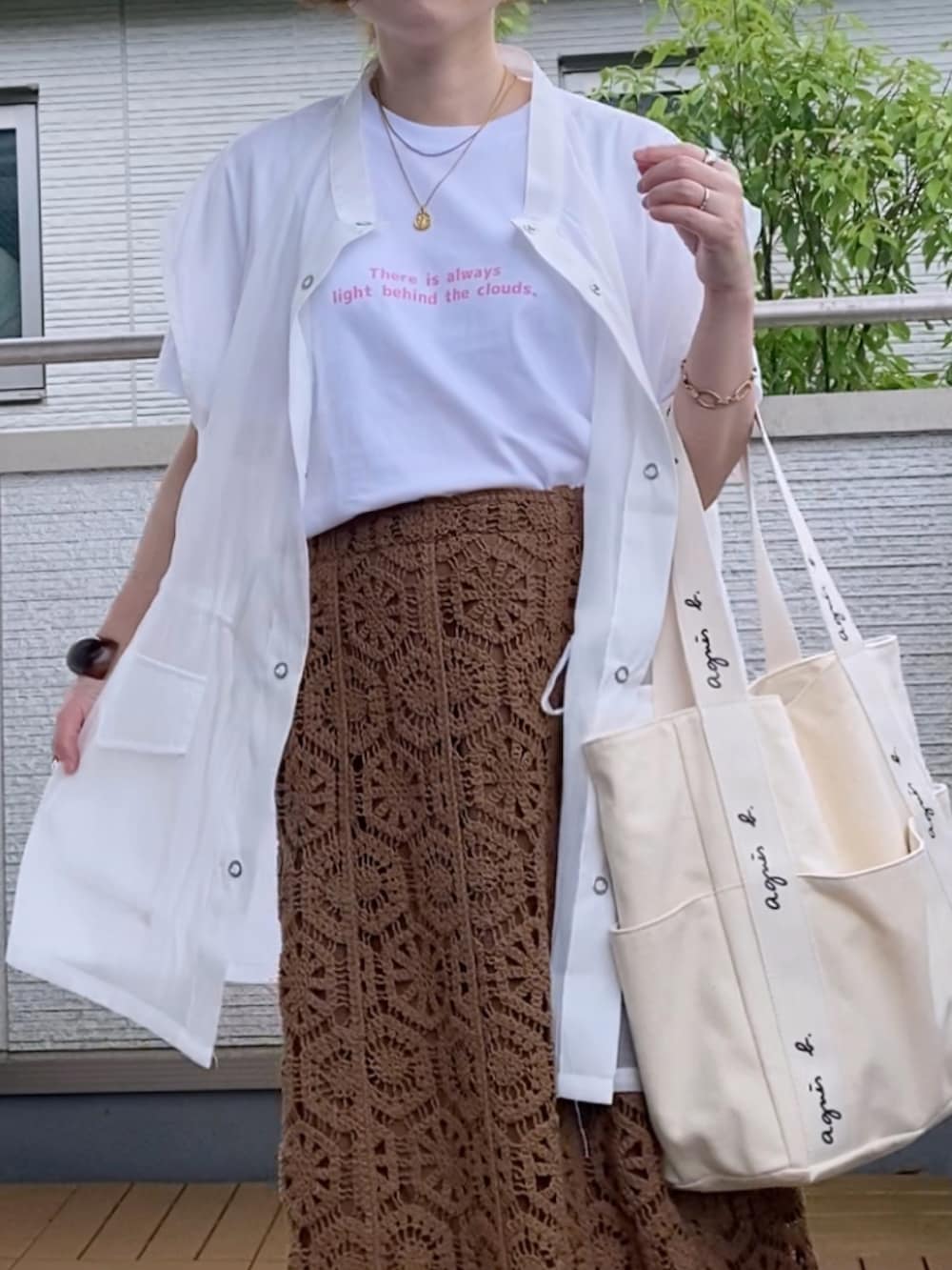 ピンク系のTシャツ/カットソー、ホワイト系のベスト、ブラウン系のスカートを着用したレディースの夏コーディネートの2枚目の写真