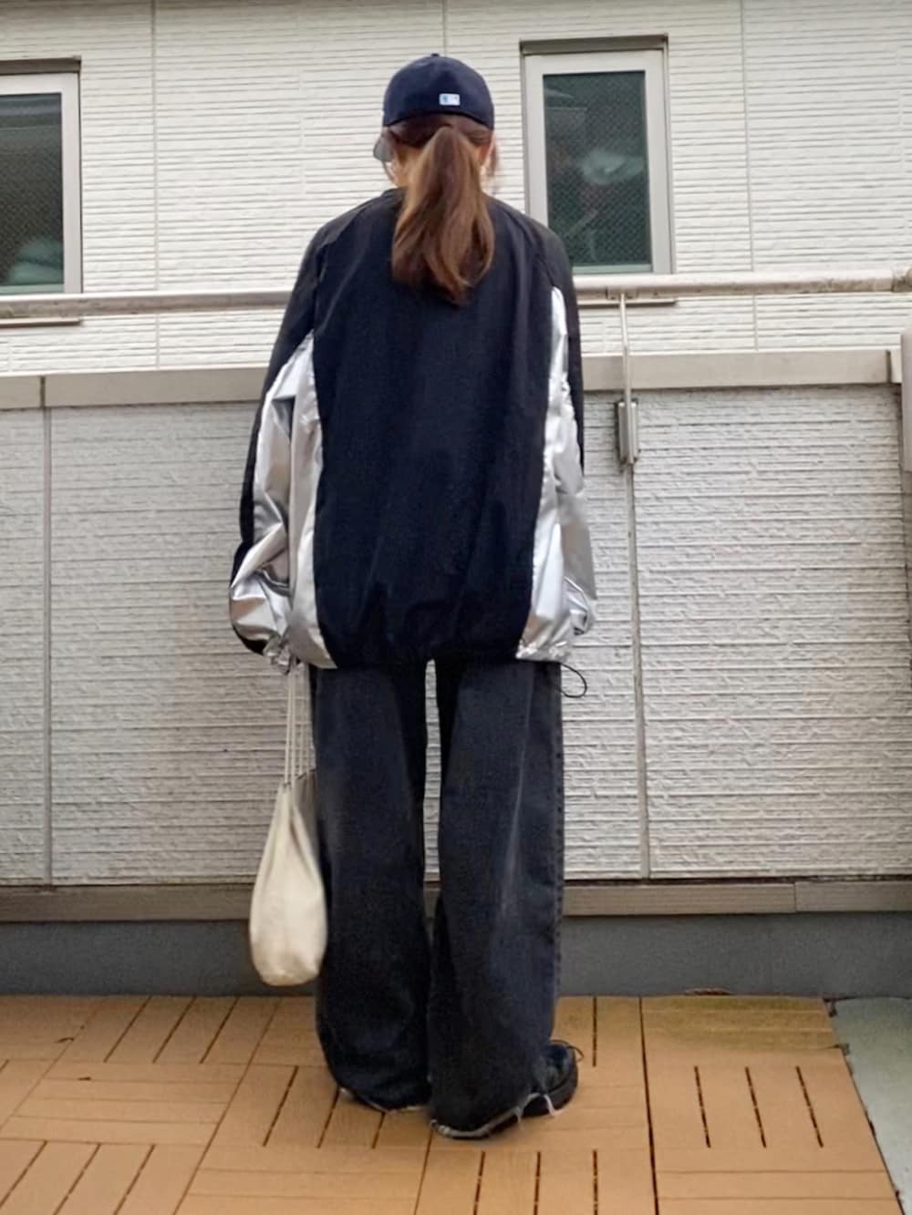 ブラック系のトップス、ブラック系のデニムパンツ、ブラック系のスニーカーを着用したレディースの秋コーディネートの4枚目の写真