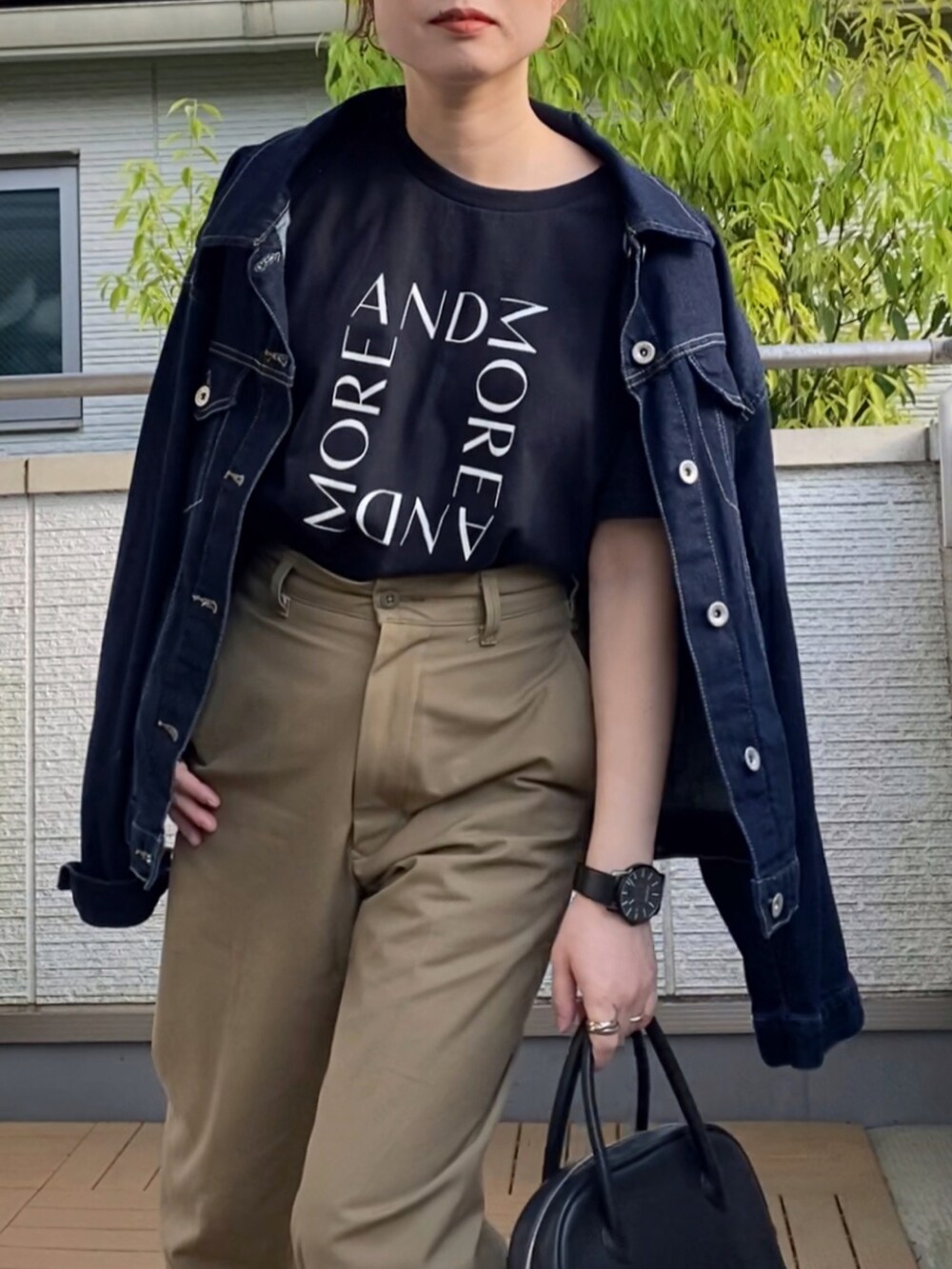 ブラック系のTシャツ/カットソー、ベージュ系のチノパンツ、ブラック系のショルダーバッグを着用したレディースの春コーディネートの3枚目の写真