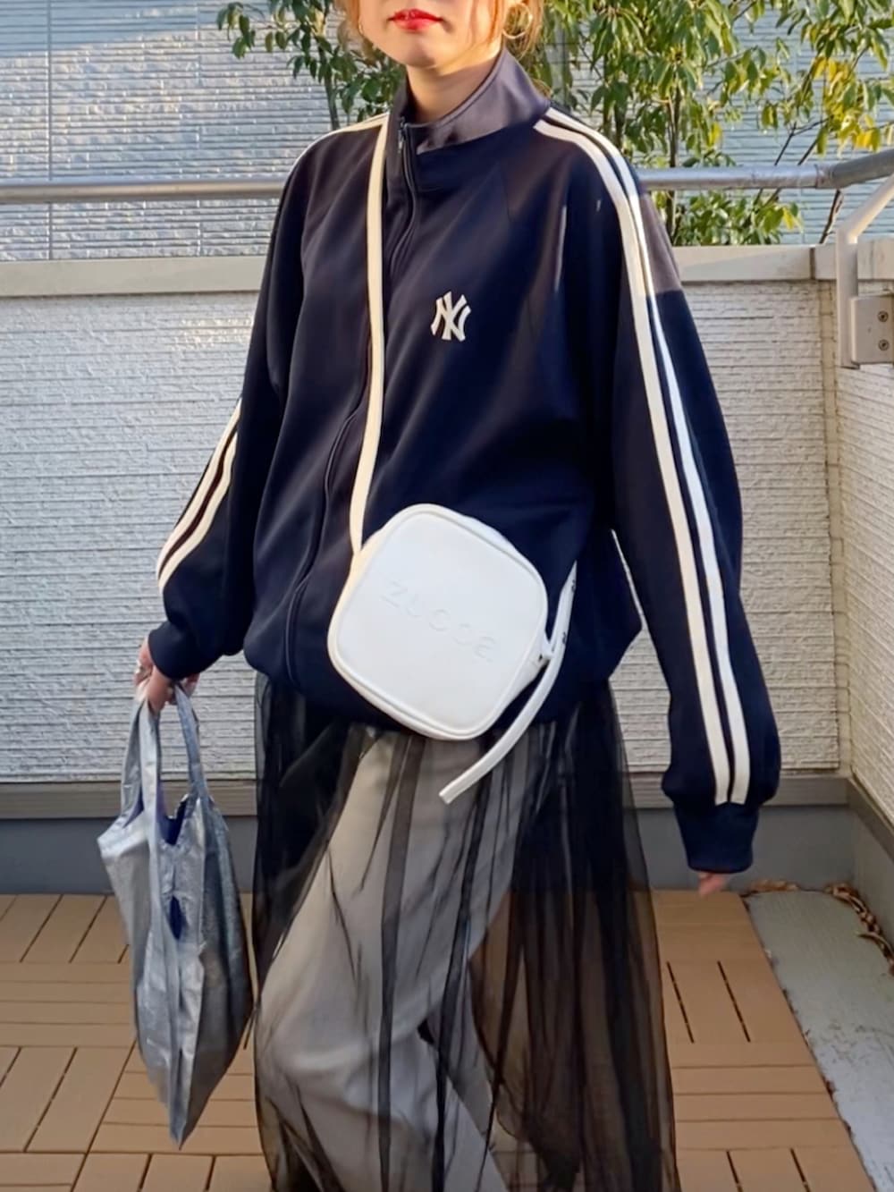 ブルー系のジャージ、ベージュ系のその他パンツ、ブラック系のワンピースを着用したレディースの春コーディネートの4枚目の写真