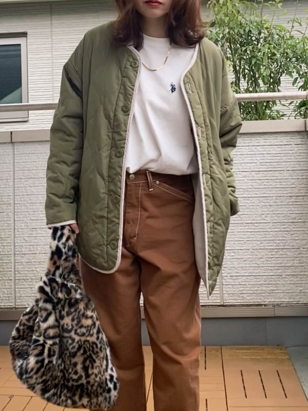 グリーン系のノーカラージャケット、ホワイト系のTシャツ/カットソー、ブラウン系のデニムパンツを着用したレディースの秋コーディネートの2枚目の写真