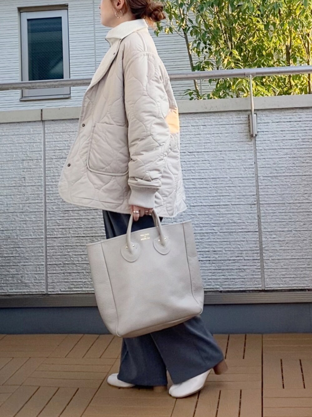 ベージュ系のブルゾン、ベージュ系のスウェット、グレー系のスラックスを着用したレディースの秋コーディネートの3枚目の写真