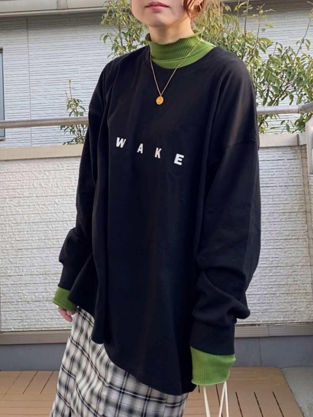 ブラック系のTシャツ/カットソー、グリーン系のTシャツ/カットソー、ブラック系のスカートを着用したレディースの春コーディネートの3枚目の写真