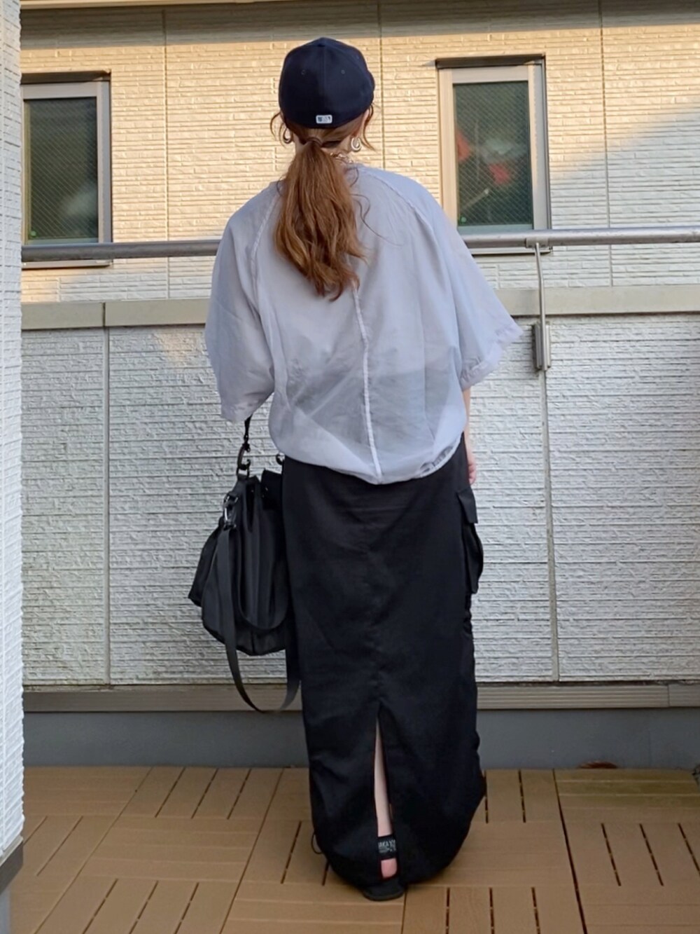 グレー系のその他トップス、ブラック系のスカート、ブラック系のショルダーバッグを着用したレディースの夏コーディネートの3枚目の写真