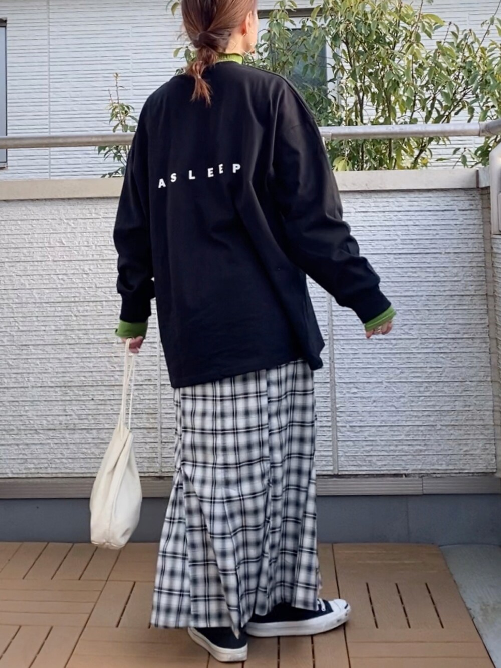 ブラック系のTシャツ/カットソー、グリーン系のTシャツ/カットソー、ブラック系のスカートを着用したレディースの春コーディネートの2枚目の写真