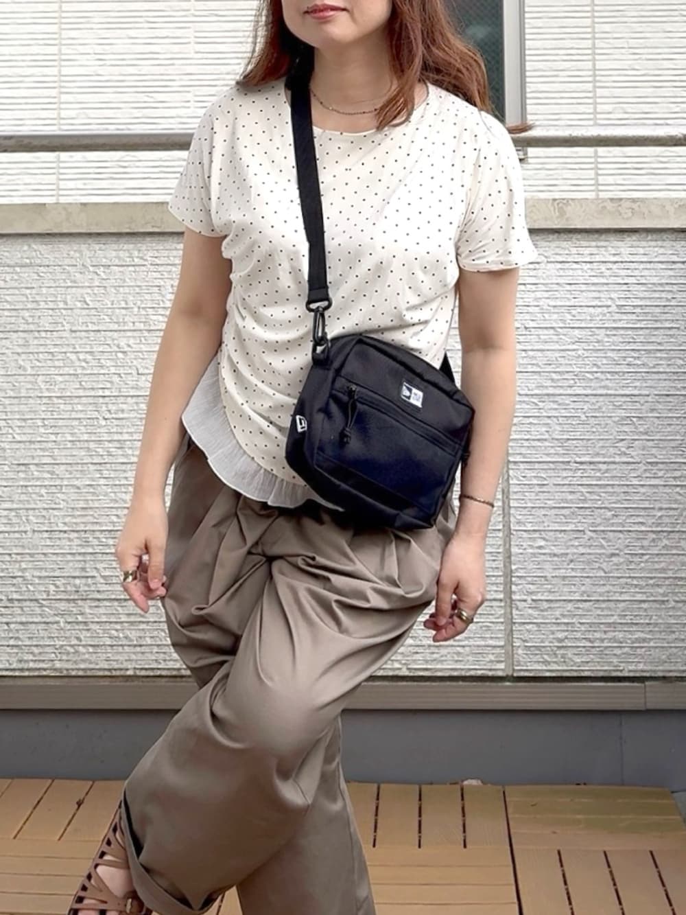 ホワイト系のTシャツ/カットソー、ブラック系のショルダーバッグ、ベージュ系のチノパンツを着用したレディースの夏コーディネートの3枚目の写真