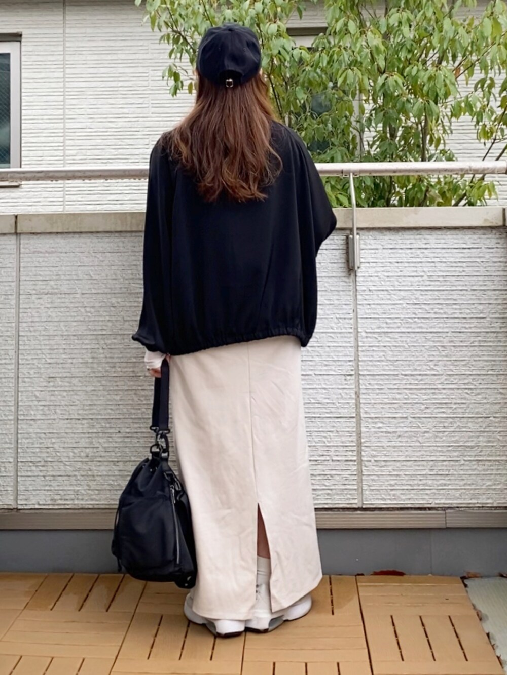 ブラック系のブルゾン、ホワイト系のワンピース、ホワイト系のTシャツ/カットソーを着用したレディースの春コーディネートの3枚目の写真