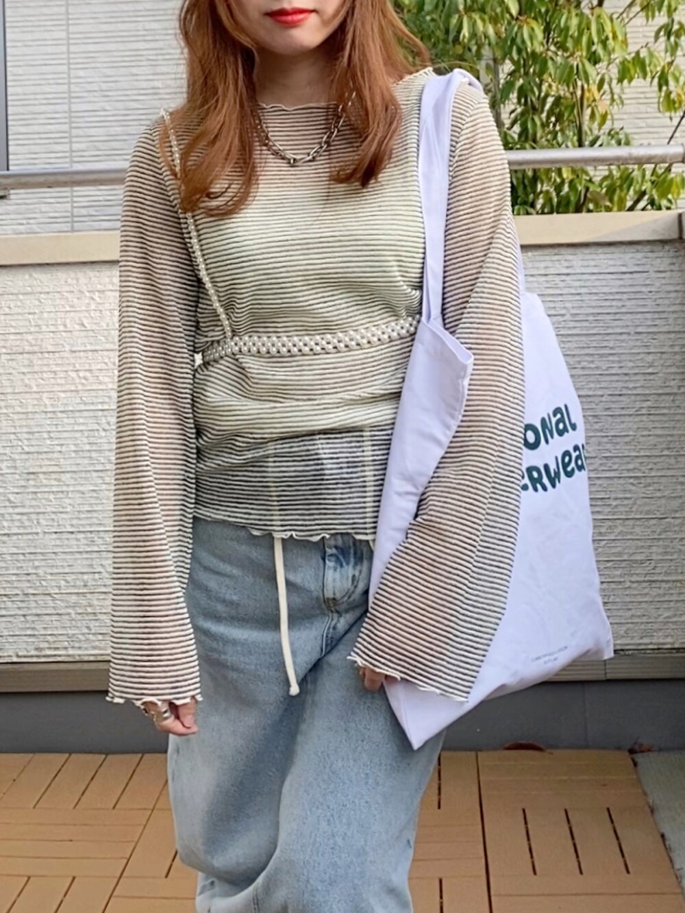 ホワイト系のTシャツ/カットソー、ブルー系のデニムスカート、ホワイト系のトートバッグを着用したレディースの春コーディネートの5枚目の写真