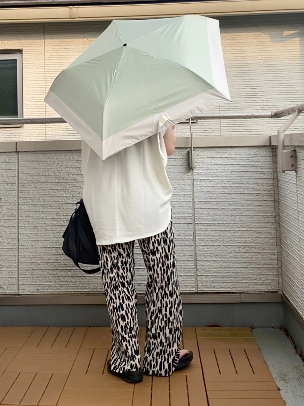 ホワイト系のTシャツ/カットソー、ホワイト系のその他パンツ、ブラック系のショルダーバッグを着用したレディースの夏コーディネートの2枚目の写真