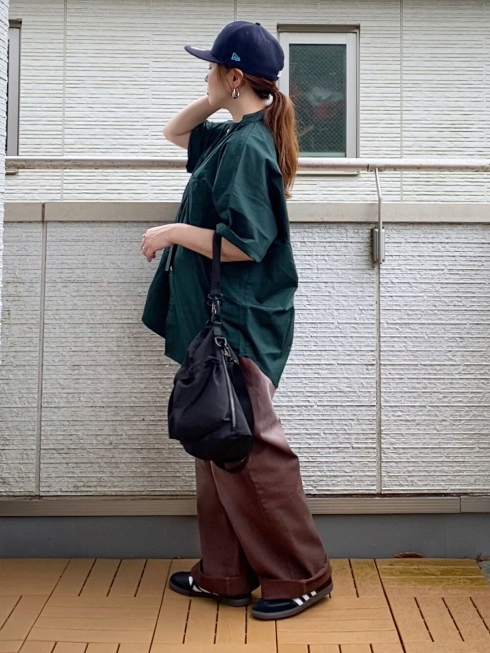 グリーン系のシャツ/ブラウス、ブラウン系のデニムパンツ、ブラック系のショルダーバッグを着用したレディースの夏コーディネートの3枚目の写真
