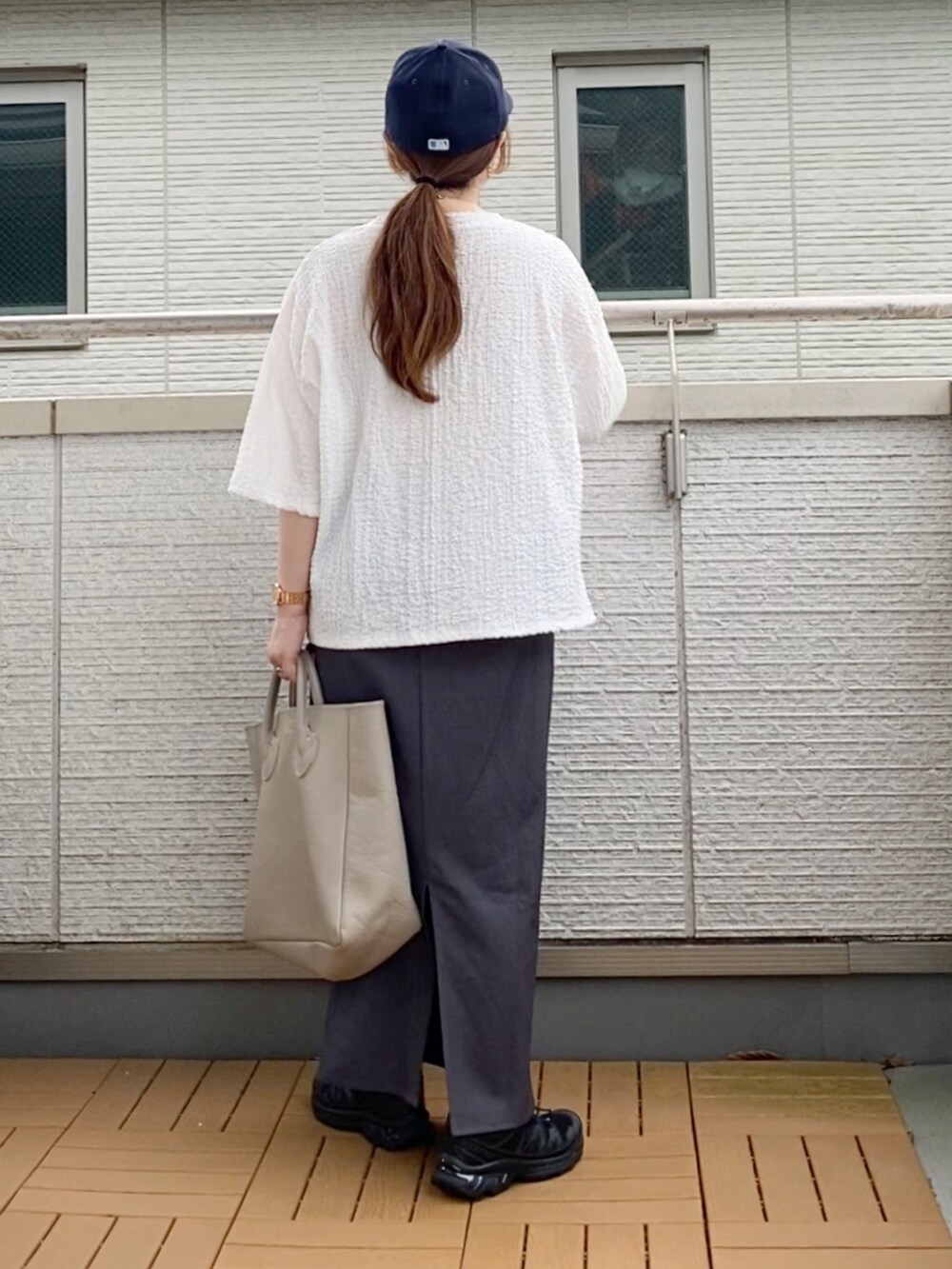 ホワイト系のシャツ/ブラウス、グレー系のスカート、ベージュ系のトートバッグを着用したレディースの夏コーディネートの2枚目の写真
