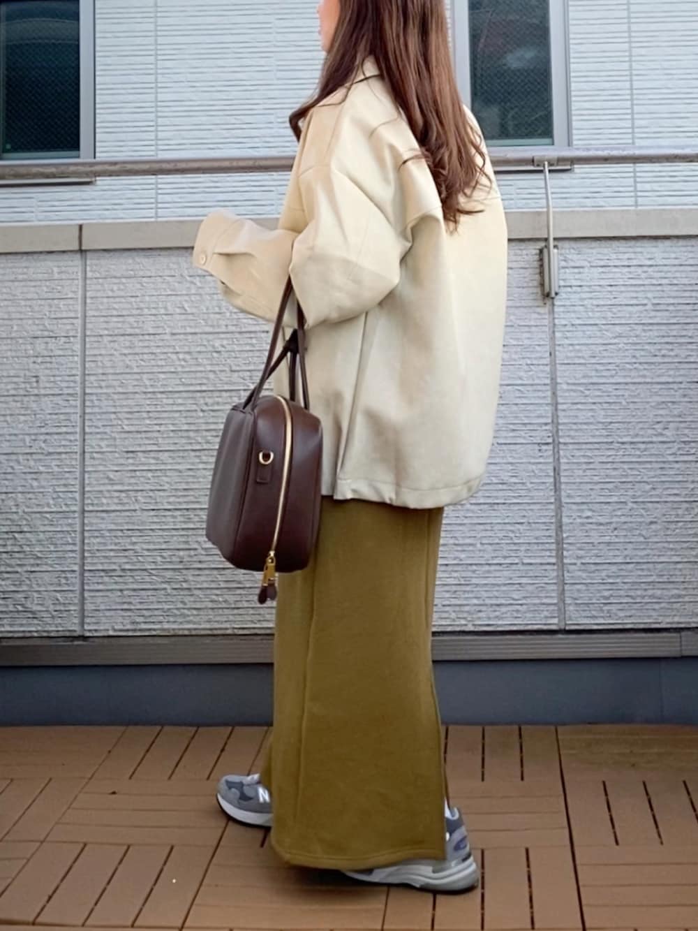 ホワイト系のブルゾン、ホワイト系のニット/セーター、グリーン系のスカートを着用したレディースの冬コーディネートの4枚目の写真