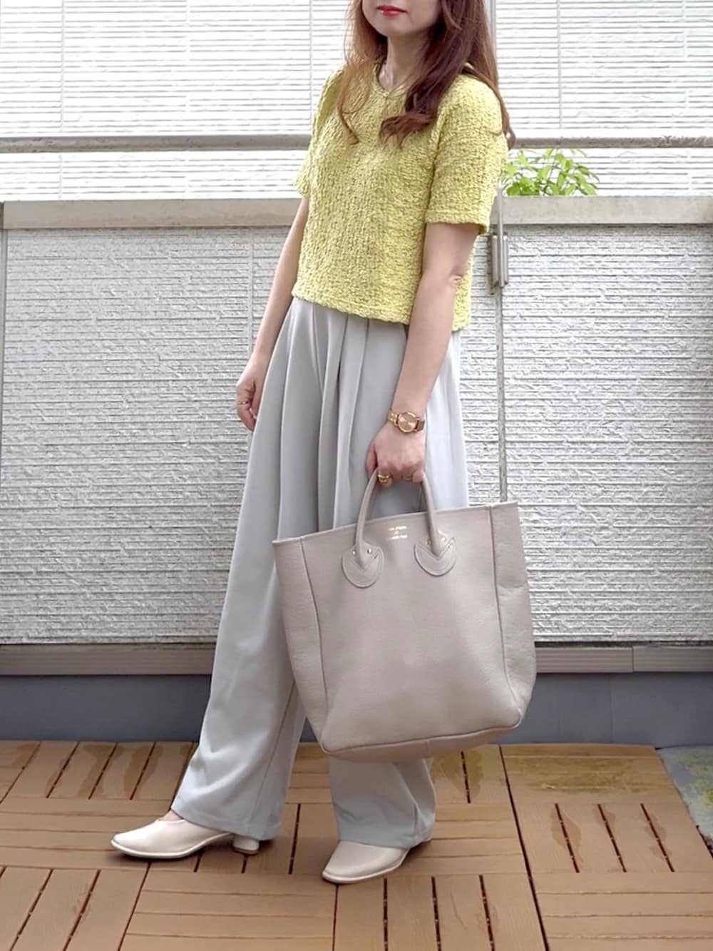 グリーン系のTシャツ/カットソー、グレー系のスラックス、ゴールド系のアナログ腕時計を着用したレディースの夏コーディネートの2枚目の写真