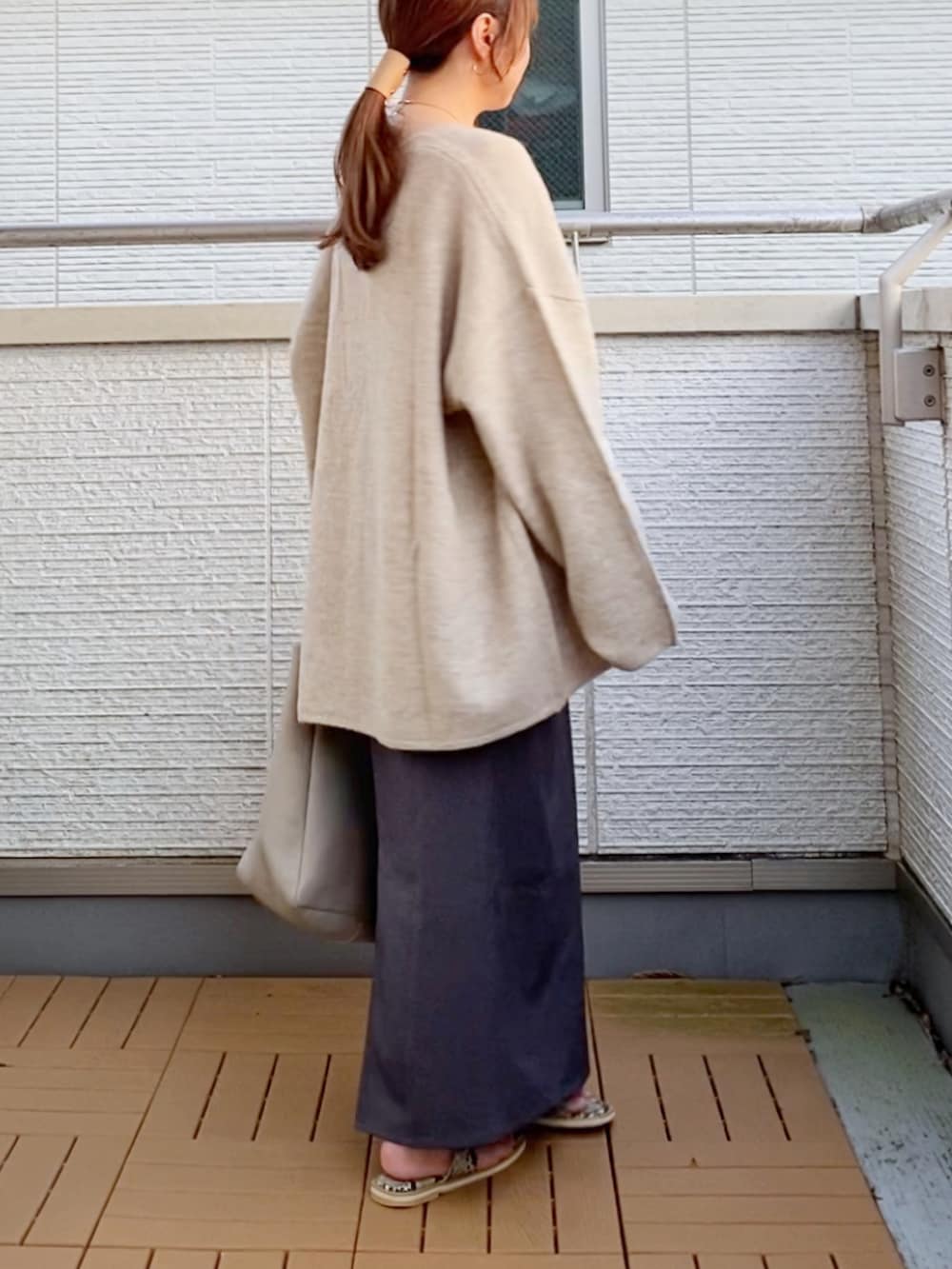 ベージュ系のカーディガン/ボレロ、グレー系のスカート、ベージュ系のトートバッグを着用したレディースの秋コーディネートの3枚目の写真