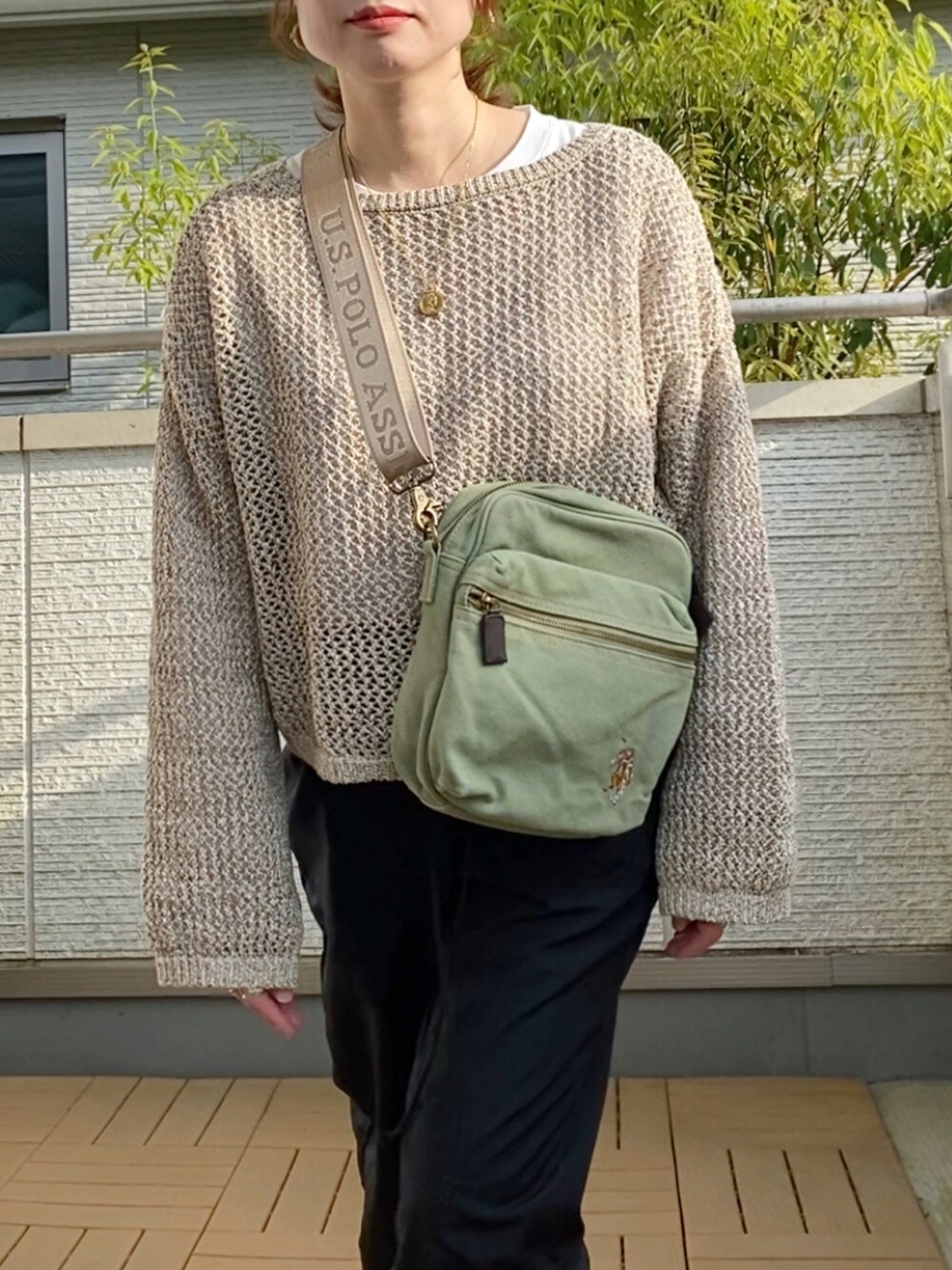 ベージュ系のニット/セーター、ブラック系のカーゴパンツ、グリーン系のショルダーバッグを着用したレディースの春コーディネートの2枚目の写真