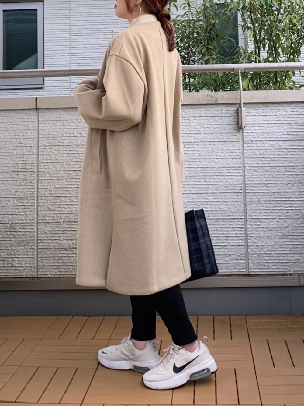 ベージュ系のその他アウター、ホワイト系のニット/セーター、ブルー系のトートバッグを着用したレディースの秋コーディネートの3枚目の写真