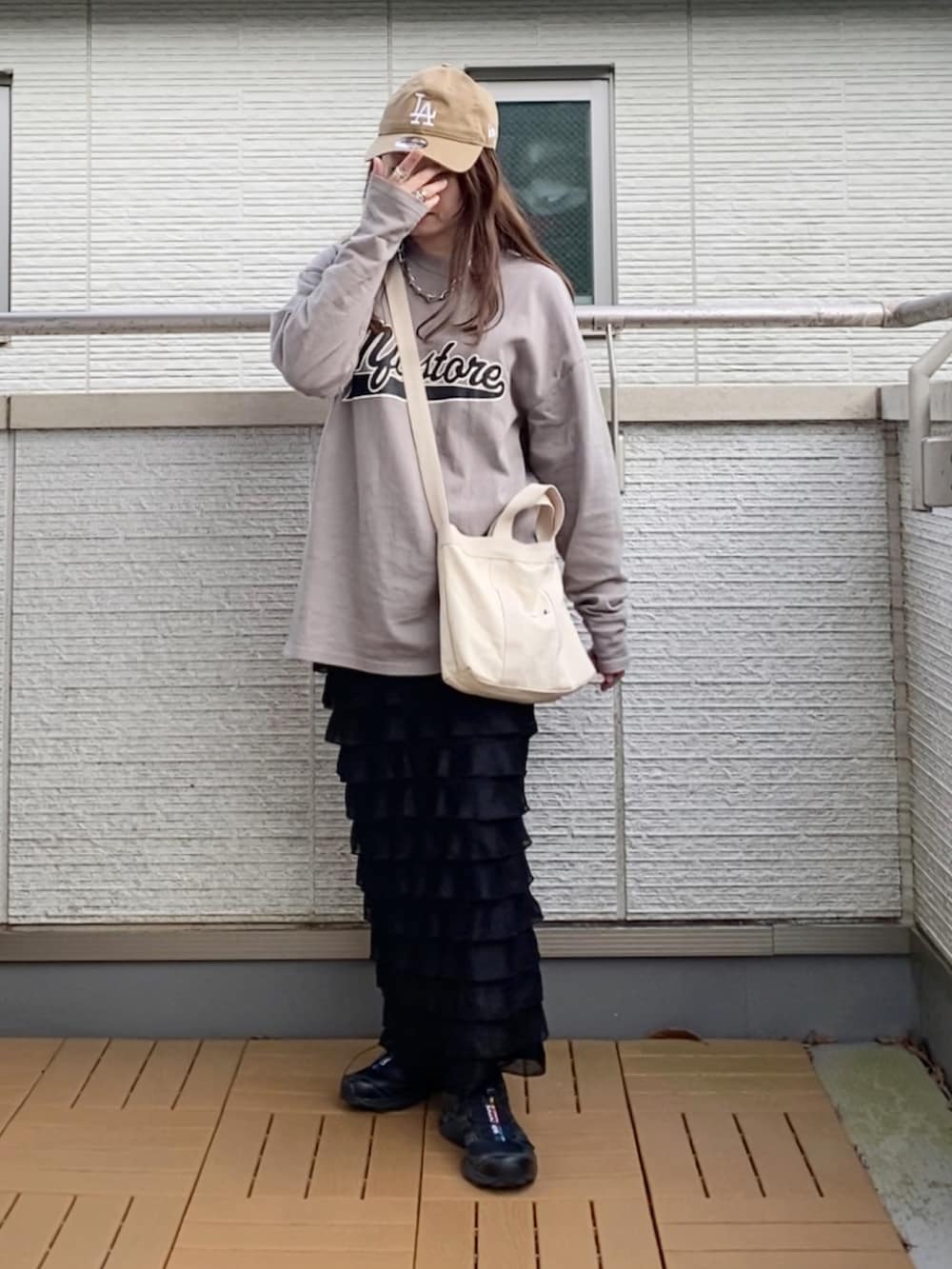グレー系のTシャツ/カットソー、ブラック系のスカート、ホワイト系のトートバッグを着用したレディースの春コーディネートの3枚目の写真
