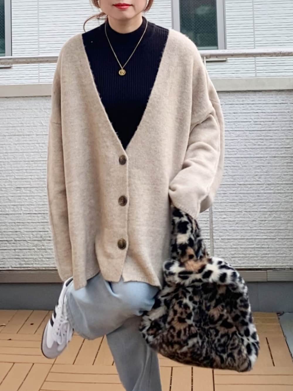 ブラック系のニット/セーター、ベージュ系のカーディガン/ボレロ、ブルー系のデニムパンツを着用したレディースの冬コーディネートの4枚目の写真