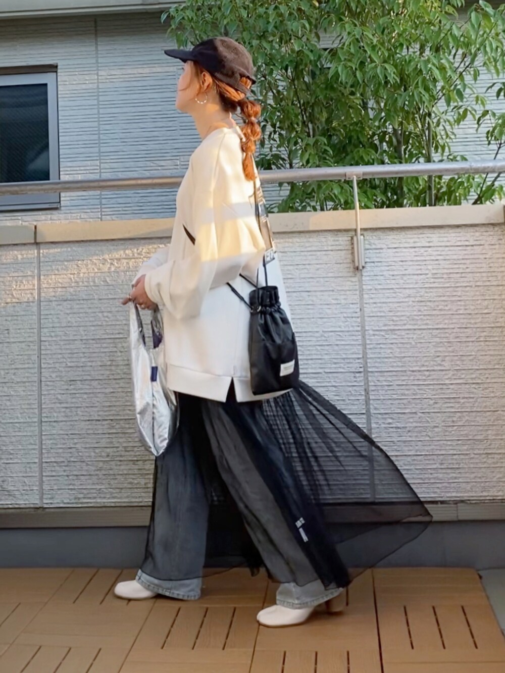 ホワイト系のスウェット、ブラック系のワンピース、ブルー系のデニムパンツを着用したレディースの秋コーディネートの3枚目の写真