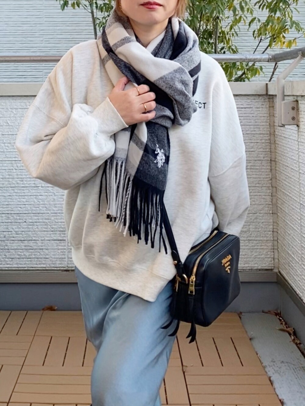 グレー系のスウェット、ブルー系のスカート、ブラック系のスニーカーを着用したレディースの冬コーディネートの3枚目の写真