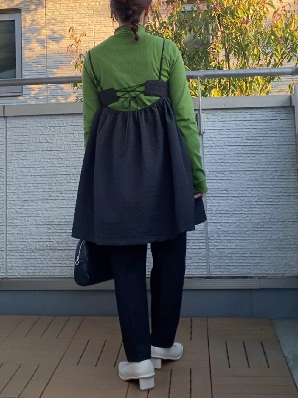 ブラック系のワンピース、グリーン系のTシャツ/カットソー、ブラック系のその他パンツを着用したレディースの春コーディネートの3枚目の写真