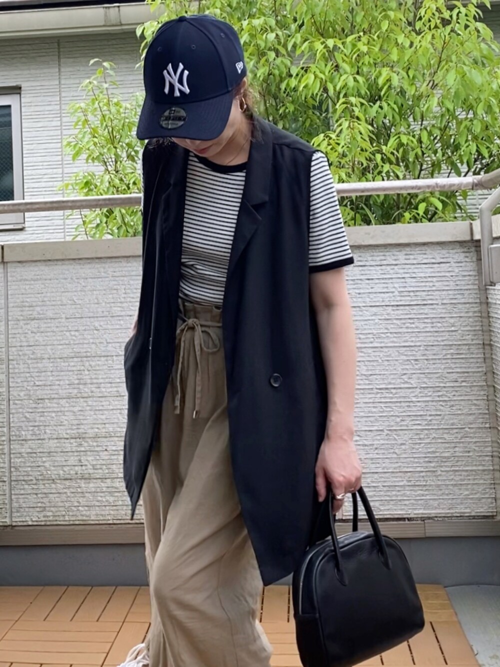 ホワイト系のTシャツ/カットソー、ブラック系のベスト、ベージュ系のその他パンツを着用したレディースの夏コーディネートの4枚目の写真