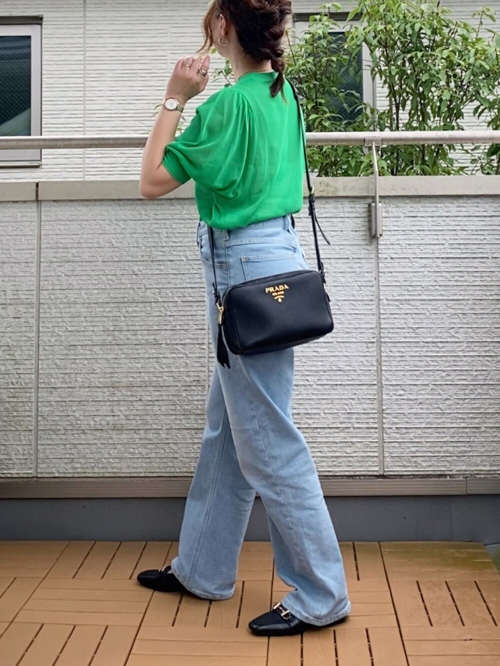 グリーン系のニット/セーター、ブルー系のデニムパンツ、ブラック系のパンプスを着用したレディースの夏コーディネートの2枚目の写真