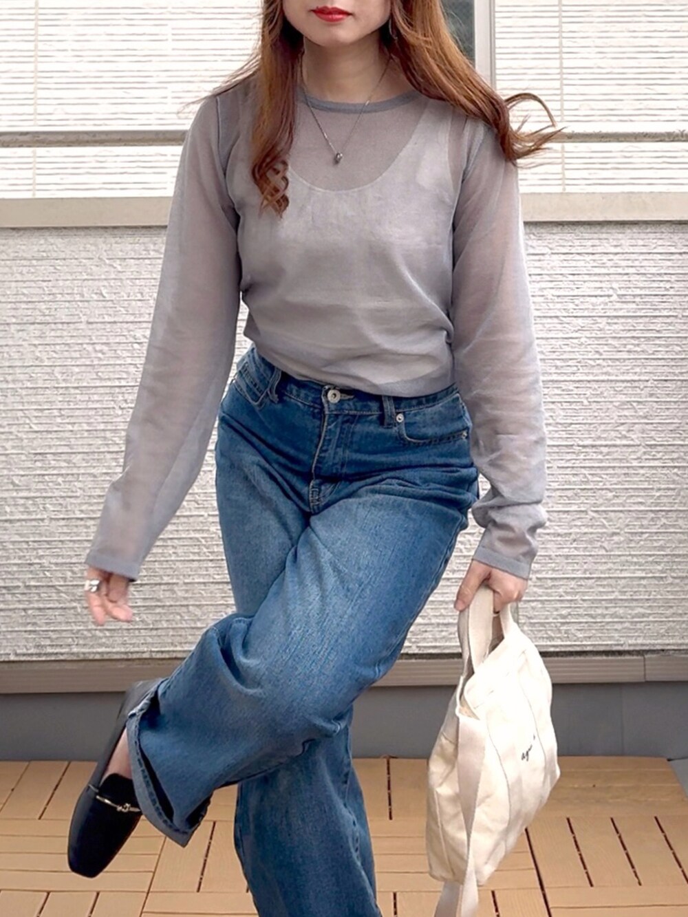 グレー系のニット/セーター、ブルー系のデニムパンツ、ホワイト系のトートバッグを着用したレディースの春コーディネートの5枚目の写真