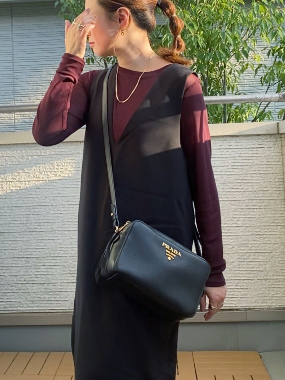 ブラウン系のTシャツ/カットソー、ブラック系のジャンパースカート、ブラック系のブーツを着用したレディースの秋コーディネートの4枚目の写真