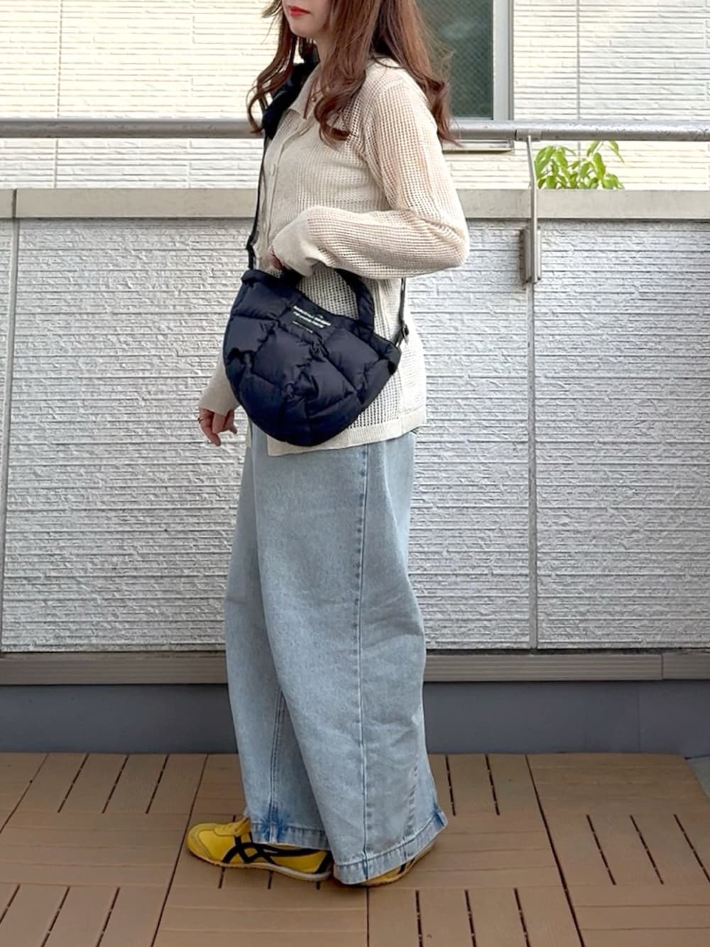 ベージュ系のカーディガン/ボレロ、ブルー系のデニムスカート、ブラック系のショルダーバッグを着用したレディースの春コーディネートの3枚目の写真