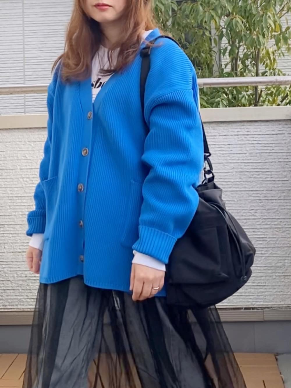 ブルー系のカーディガン/ボレロ、ホワイト系のTシャツ/カットソー、ブラック系のワンピースを着用したレディースの冬コーディネートの4枚目の写真