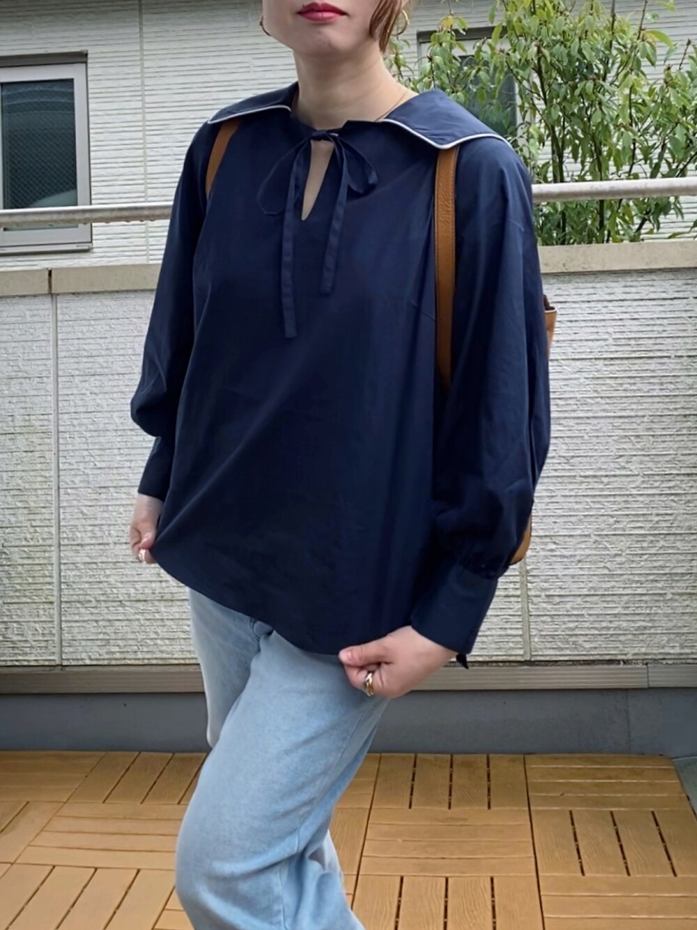 ブルー系のシャツ/ブラウス、ブルー系のデニムパンツ、イエロー系のバックパック/リュックを着用したレディースの春コーディネートの4枚目の写真