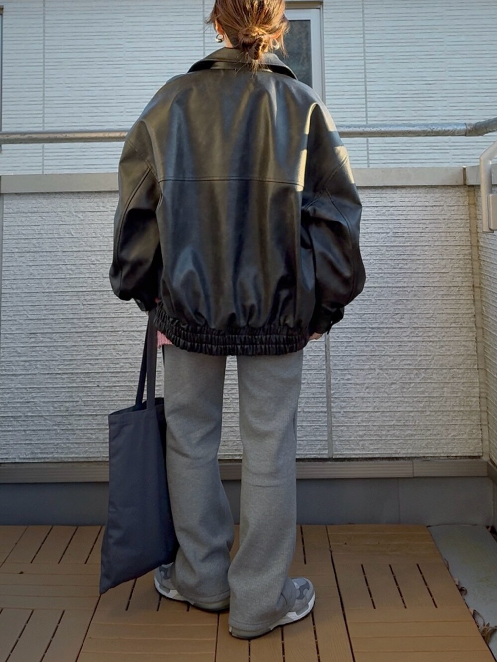 ブラック系のブルゾン、ピンク系のニット/セーター、グレー系のその他パンツを着用したレディースの冬コーディネートの3枚目の写真