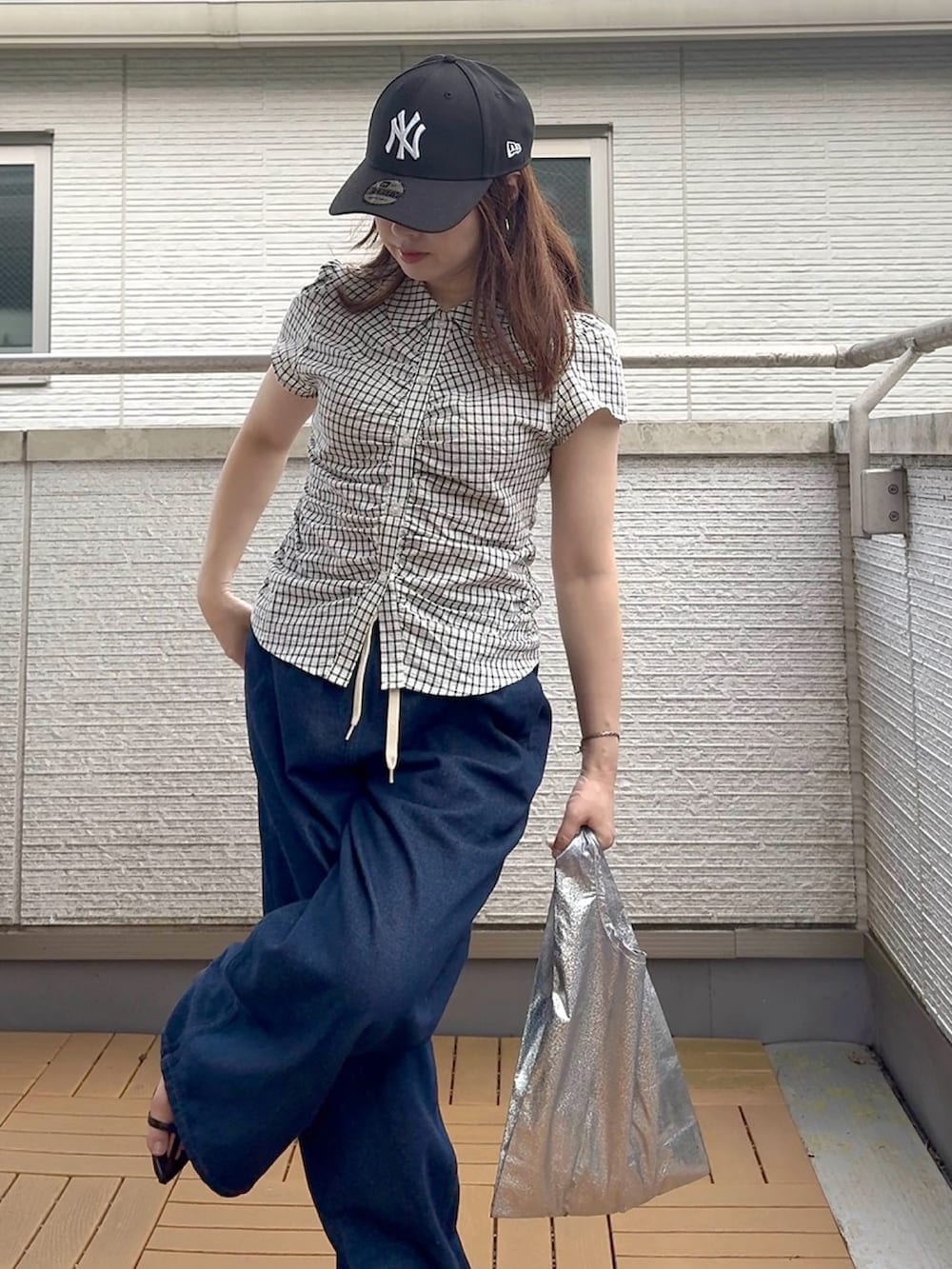 ホワイト系のシャツ/ブラウス、ブルー系のデニムパンツ、ブラック系のキャップを着用したレディースの夏コーディネートの4枚目の写真