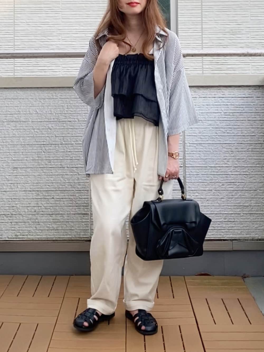 ブラック系のハンドバッグ、ブラック系のキャミソール、その他のシャツ/ブラウスを着用したレディースの夏コーディネートの2枚目の写真