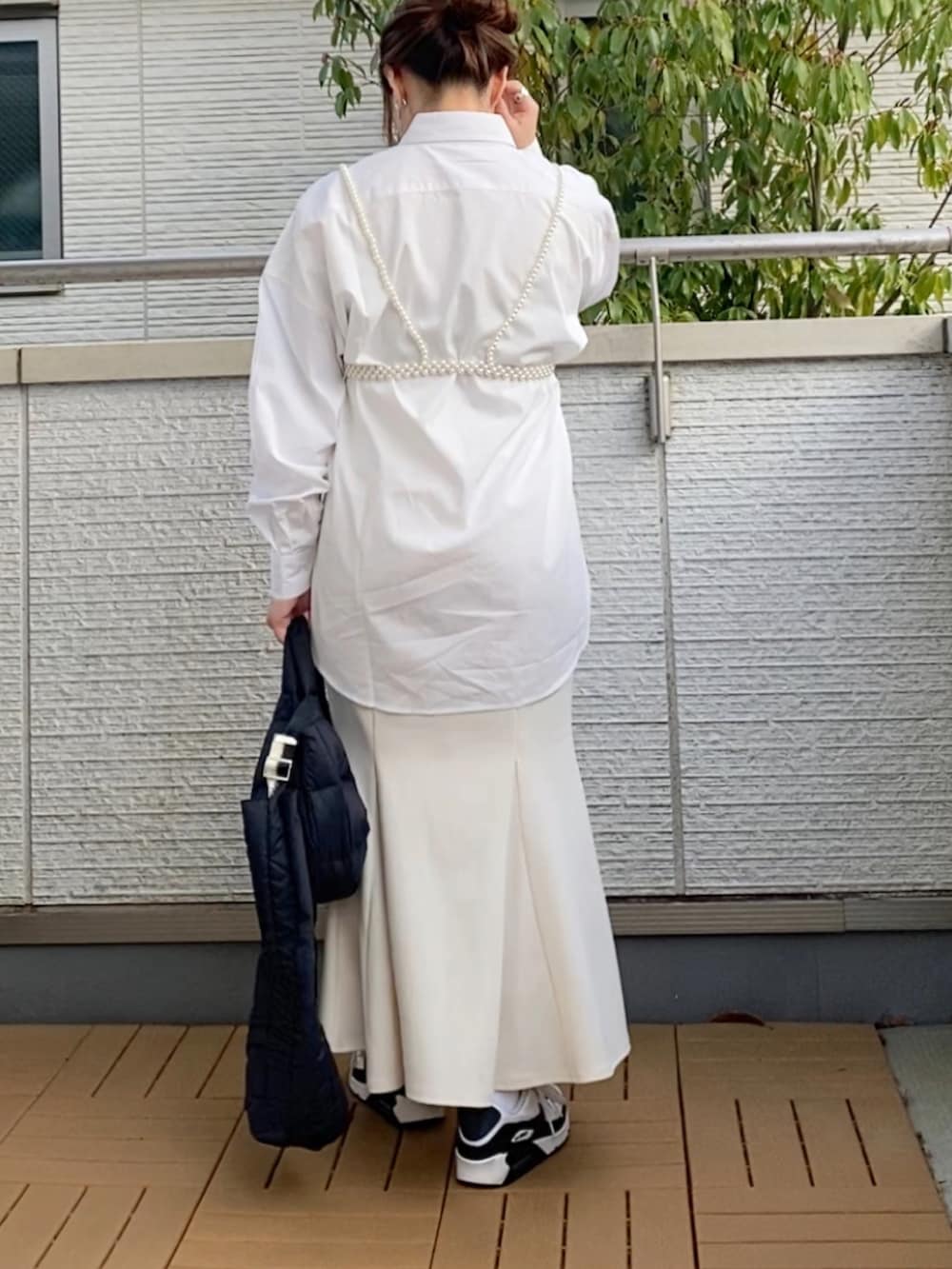 ホワイト系のシャツ/ブラウス、ホワイト系のスカート、ブラック系のショルダーバッグを着用したレディースの春コーディネートの3枚目の写真