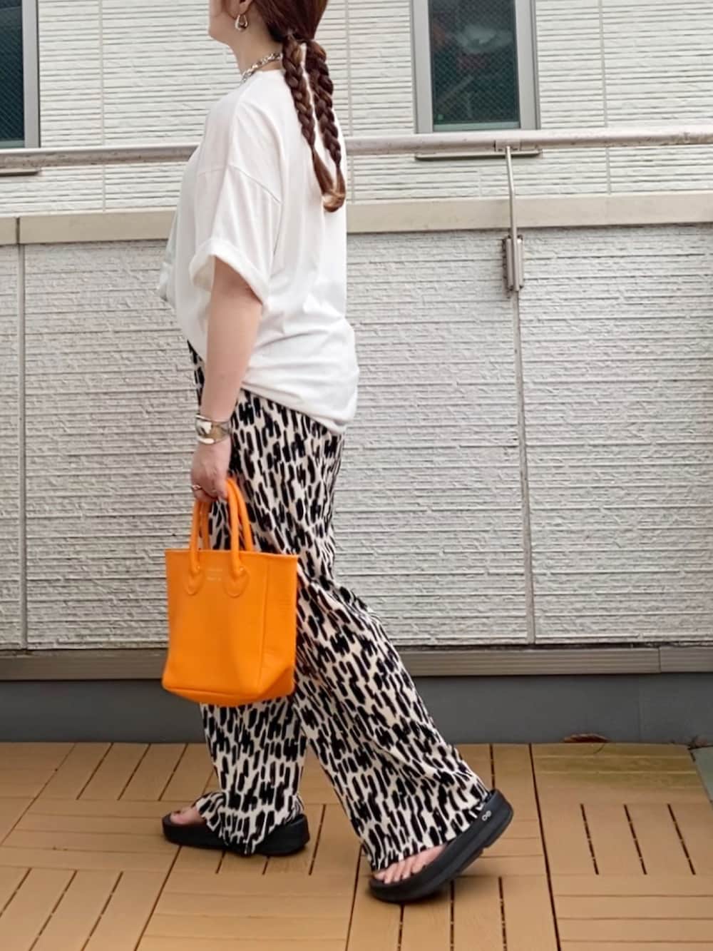 ホワイト系のTシャツ/カットソー、ホワイト系のその他パンツ、オレンジ系のトートバッグを着用したレディースの夏コーディネートの3枚目の写真