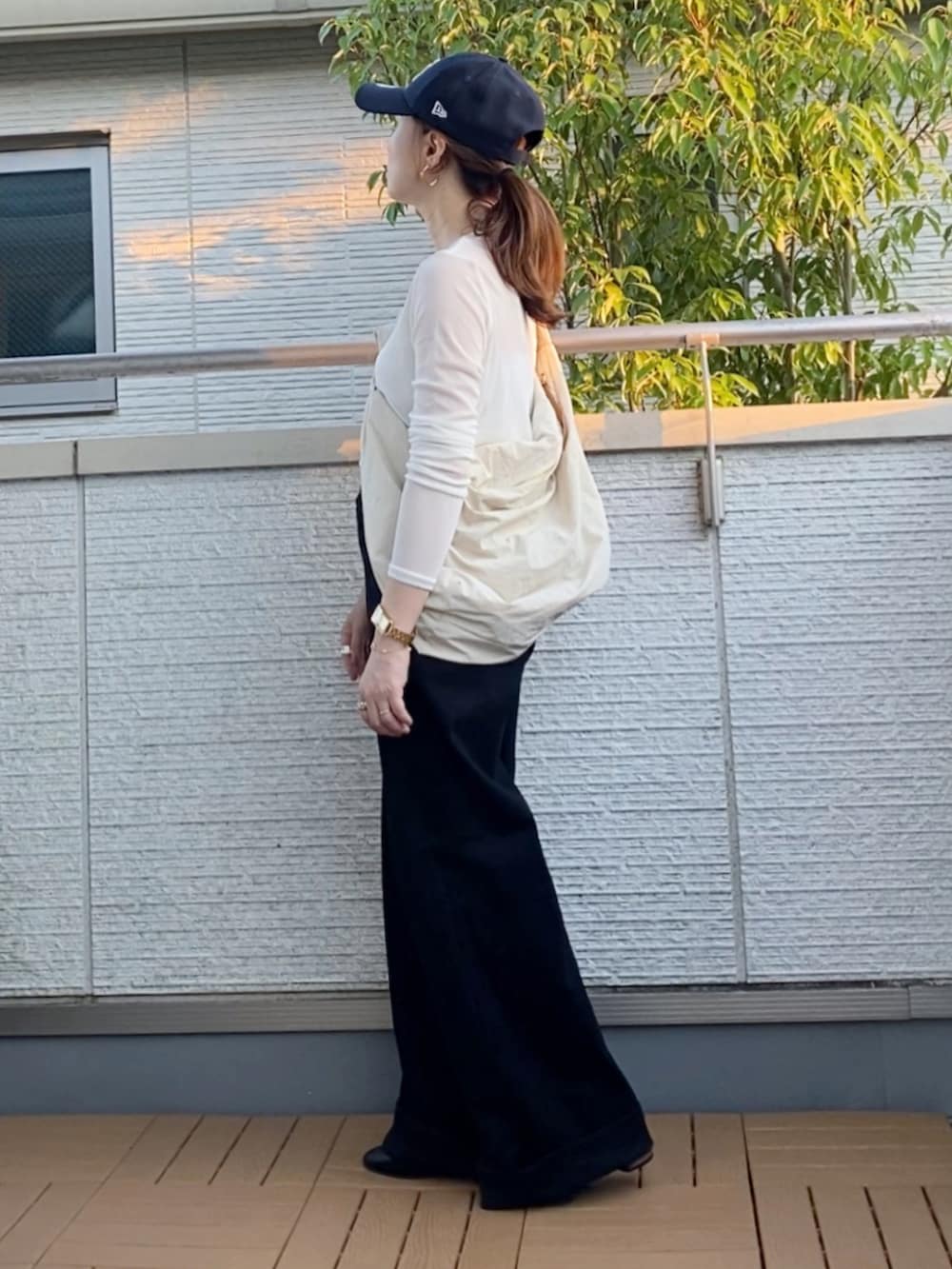 ホワイト系のTシャツ/カットソー、ブラック系のデニムパンツ、ホワイト系のショルダーバッグを着用したレディースの秋コーディネートの2枚目の写真