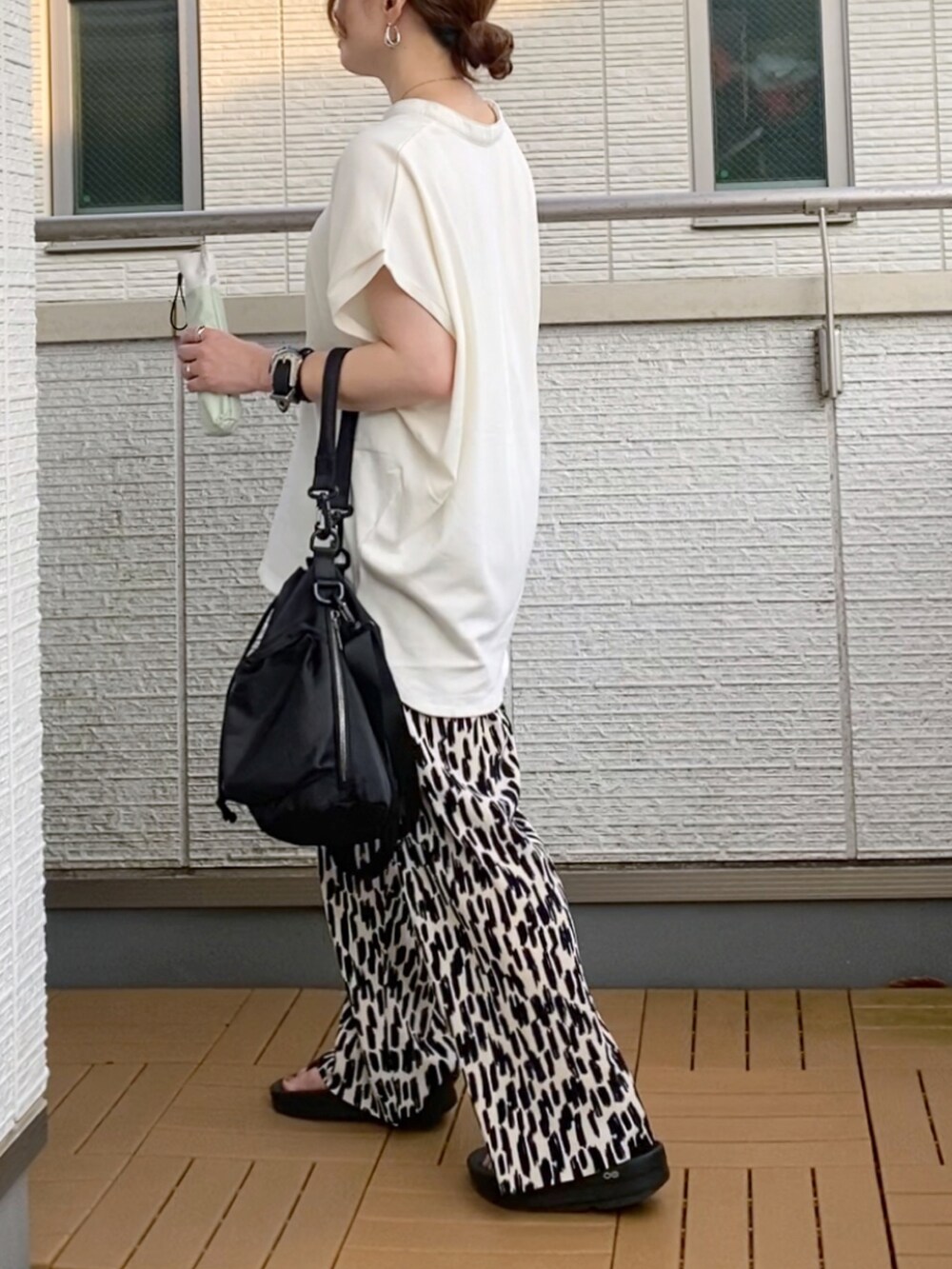 ホワイト系のTシャツ/カットソー、ホワイト系のその他パンツ、ブラック系のショルダーバッグを着用したレディースの夏コーディネートの3枚目の写真