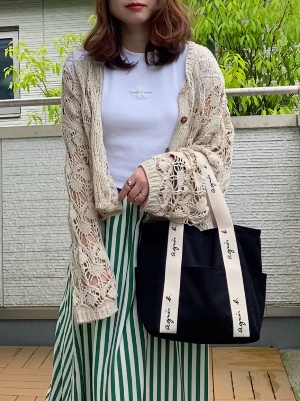 ホワイト系のTシャツ/カットソー、ホワイト系のカーディガン/ボレロ、グリーン系のスカートを着用したレディースの春コーディネートの2枚目の写真