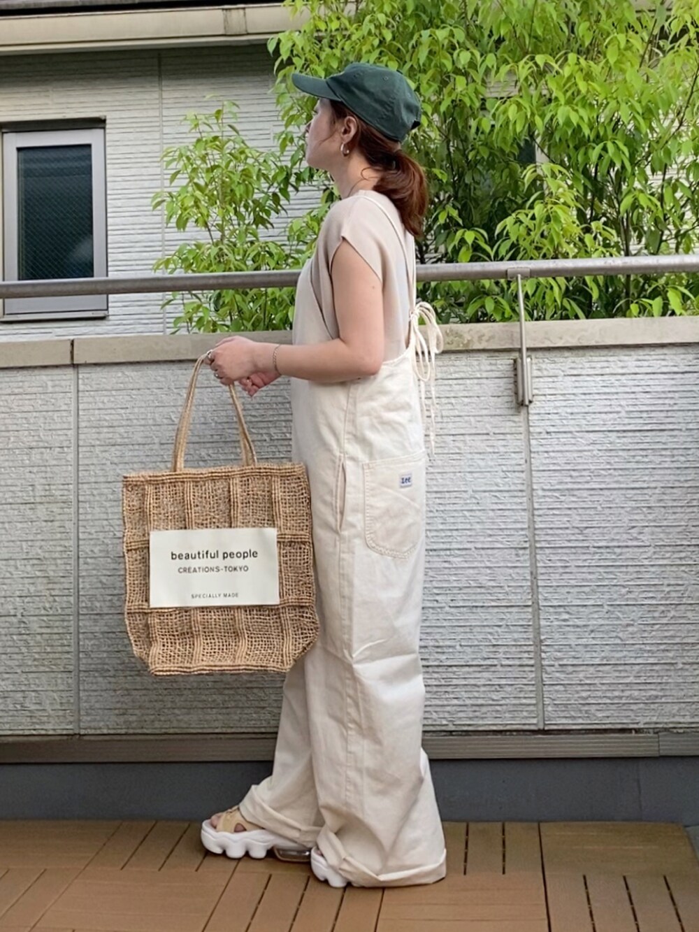 ベージュ系のニット/セーター、ベージュ系のバッグ、ブラウン系のサンダルを着用したレディースの春コーディネートの2枚目の写真