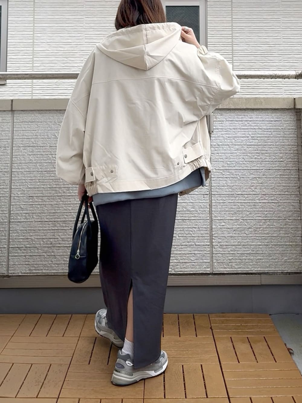 ホワイト系のマウンテンパーカー、ブルー系のスウェット、グレー系のスカートを着用したレディースの春コーディネートの4枚目の写真