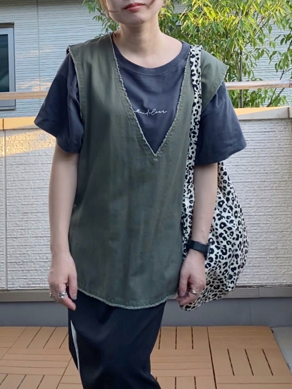 グリーン系のベスト、グレー系のTシャツ/カットソー、ブラック系のスカートを着用したレディースの秋コーディネートの3枚目の写真