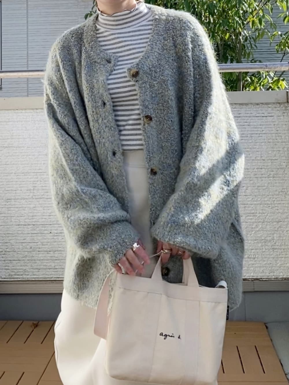 グレー系のカーディガン/ボレロ、その他のTシャツ/カットソー、ホワイト系のスカートを着用したレディースの秋コーディネートの4枚目の写真