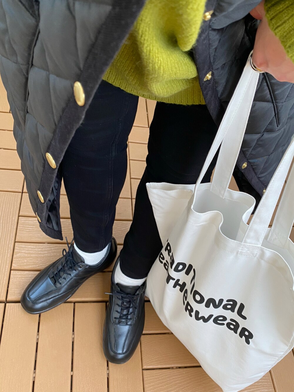 ブラック系のシューズ、ブラック系のその他アウター、ホワイト系のトートバッグを着用したレディースの秋コーディネートの3枚目の写真